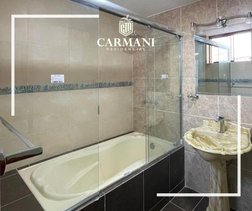 ein Badezimmer mit einer Badewanne und einem Waschbecken in der Unterkunft RESIDENCIAL CARMANI in Tacna