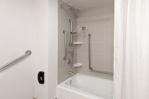 a bathroom with a shower and a bath tub with a shower curtain at TownePlace Suites by Marriott Sudbury in Sudbury
