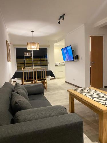uma sala de estar com um sofá e uma mesa em Duplex del Parque y Balneario em Necochea