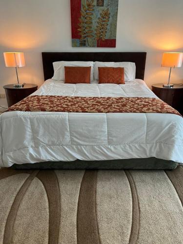 1 cama grande en un dormitorio con 2 lámparas en Spacious Garden Bungalow Escape, en Subang Jaya