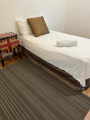 Bett in einem Zimmer mit einem schwarzen Teppich in der Unterkunft Spacious Garden Bungalow Escape in Subang Jaya