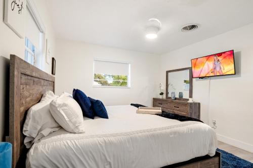 1 dormitorio con 1 cama grande y espejo en Music Lovers Villa, 4BD, 3BA, Pool, Game Room Outdoor Projector en Pembroke Pines