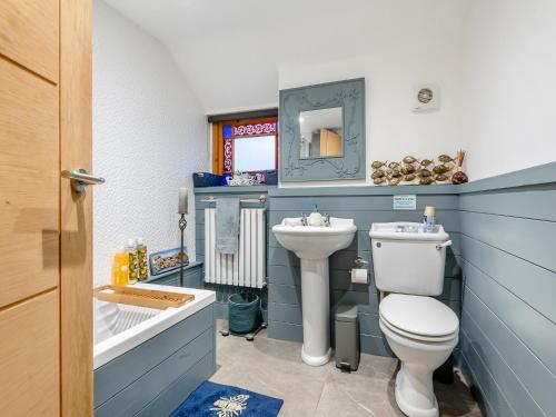 a bathroom with a toilet and a sink at Spring Cottage in Sedgeford
