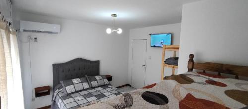 a bedroom with a bed and a television in it at Casa Ana 3 departamento a 20 min del aeropuerto de ezeiza in Luis Guillón