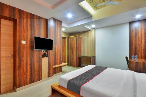 a bedroom with a bed and a flat screen tv at Townhouse 1307 Coastal Grand Hotels and Resorts in Coimbatore