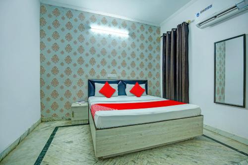 um quarto com uma cama com almofadas vermelhas e azuis em OYO HOTEL WINNER INN em Ludhiana