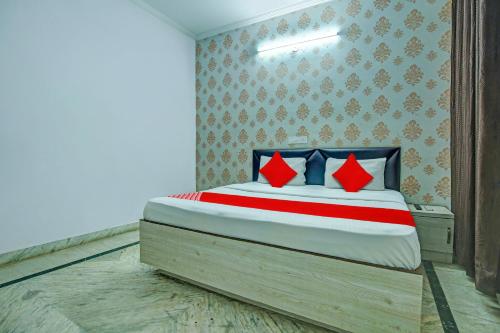 een slaapkamer met een bed met rode en blauwe kussens bij OYO HOTEL WINNER INN in Ludhiana