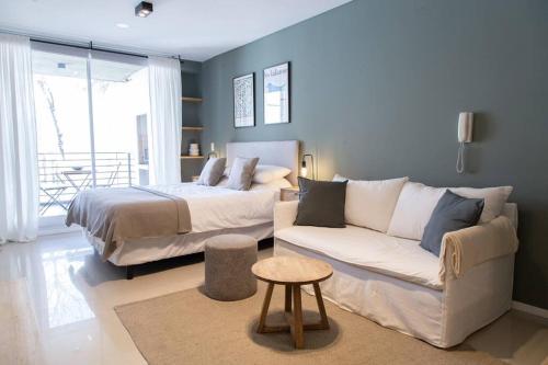 um quarto com uma cama, um sofá e uma mesa em Magnolio Homely Apartment em Buenos Aires