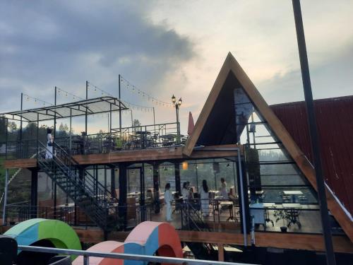 a building with a roof with people sitting at tables at Hotel Nature Bromo and Resort in Pasuruan