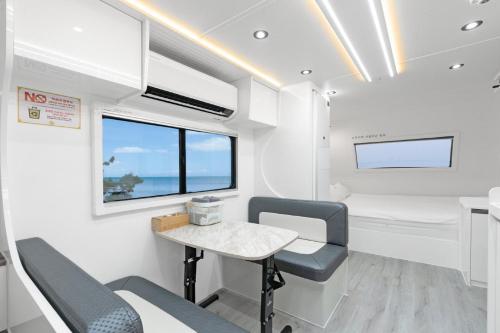 a room with a table and chairs in a caravan at Pohang Uni's Sea Guryongpo in Pohang