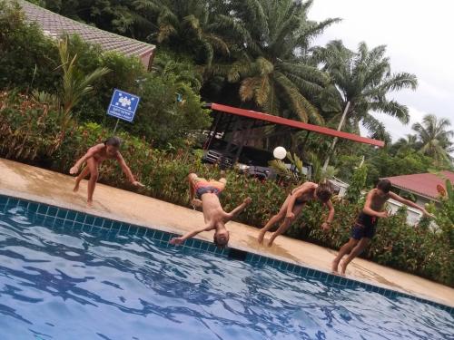 a group of people playing in a swimming pool at Sj House Hotel Aonang in Ban Khlong Haeng