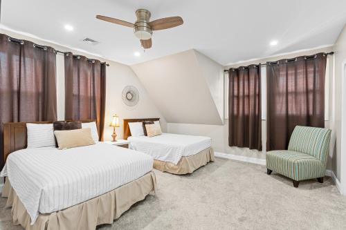 una habitación de hotel con 2 camas y una silla en Cozy 4BR, 6beds, 12 guest Home near PHL, UPENN, Fast Wi-Fi, King Bed, Parking en Lansdowne