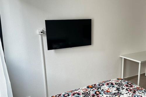 Elle comprend une télévision à écran plat suspendue au mur. dans l'établissement Studio hyper centre, à Genève