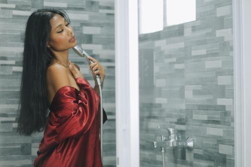 Une femme en robe rouge se brossant les dents dans l'établissement ANGEL'S DREAM RESIDENCE, à Panglao