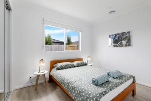 ein weißes Schlafzimmer mit einem Bett und einem Fenster in der Unterkunft Escape by the Bay in Coronet Bay