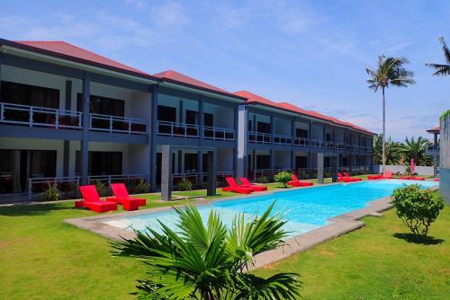 a resort with a swimming pool and red chairs at ANGEL'S DREAM RESIDENCE in Panglao