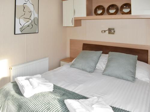 een wit bed met twee kussens erop bij Solent Village 13-uk44072 in Cowes