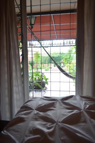 a bedroom with a bed in front of a window at Hotel Art Gallery Casona de los Milagros in Colima