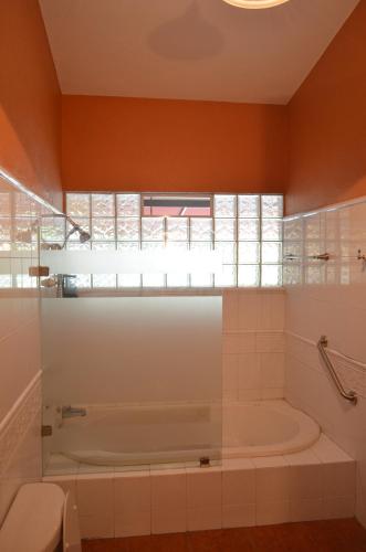 baño con bañera, aseo y ventana en Hotel Art Gallery Casona de los Milagros, en Colima