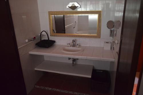 a bathroom with a sink and a mirror at Hotel Art Gallery Casona de los Milagros in Colima