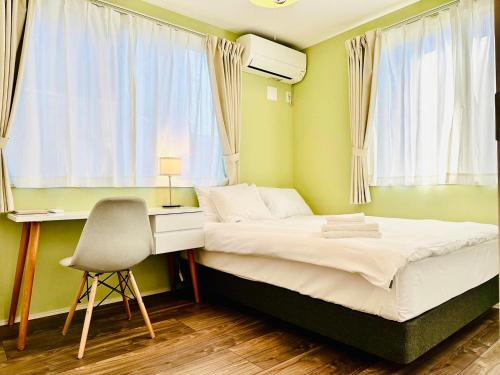 富士吉田的住宿－MEGUFUJI PLUS+，一间卧室配有一张床、一张桌子和一把椅子