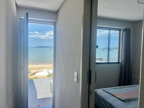 Schlafzimmer mit Meerblick von einer Tür in der Unterkunft Pé na areia! Aconchegante casa frente Mar in Governador Celso Ramos