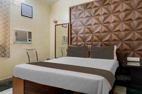 1 dormitorio con 1 cama grande y cabecero grande en OYO 82148 Hotel Galaxy Residency kalyani nagar en Pune