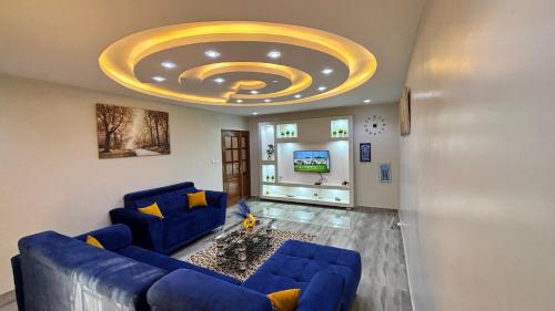 Magnifique appartement meublé à Dakar, Rte de Rufisque في داكار: غرفة معيشة مع أريكة زرقاء وسقف ذهبي