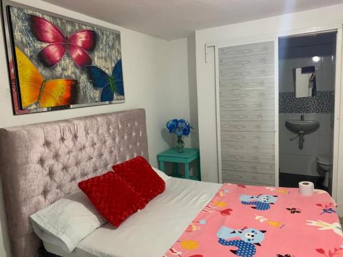 a bedroom with a bed with a pink comforter at hostal la casa de mi abuela in Barranquilla
