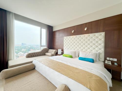 a bedroom with a large bed with a large window at Grand Tebu Hotel in Bandung