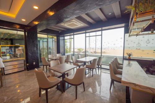 a restaurant with tables and chairs and windows at Seaside Jomtien Beach Pattaya in Jomtien Beach