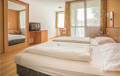 ザンクト・ローレンツェン・オプ・ムーラウにあるStunning Home In St,georgen Am Kreischb, With Sauna, Wifi And Indoor Swimming Poolのベッド2台とテレビが備わるホテルルームです。