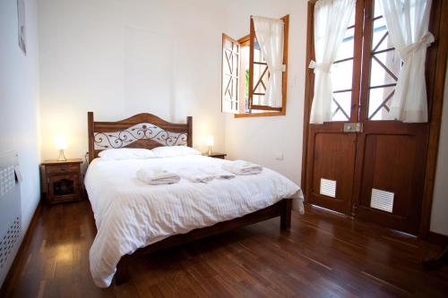 1 dormitorio con 1 cama con sábanas blancas y ventana en Arche Noah Boutique Hostel, en Bogotá