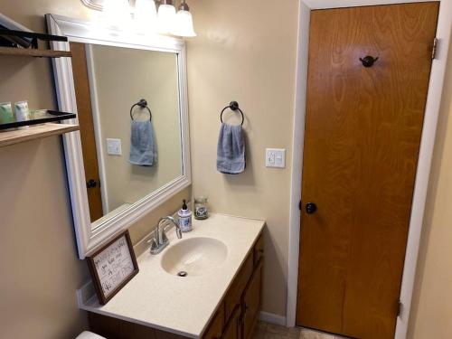 een badkamer met een wastafel en een spiegel bij Barbee Chain Lake Access! 3 Bedroom Cozy Cottage in North Webster