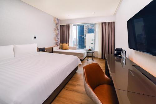 a hotel room with a bed and a flat screen tv at Traders Hotel, Kuala Lumpur in Kuala Lumpur