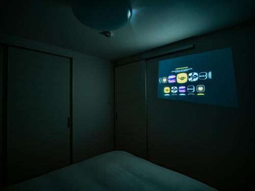 a room with a bed and a screen on the wall at Rakuten STAY HOUSE x WILL STYLE Fujinomiya in Fujinomiya
