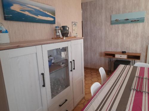 une cuisine avec une armoire blanche et une table dans l'établissement Maison T3 avec cour, à deux pas du port de l'Aiguillon, proche commodités et plage - Arcachon - FR-1-319-126, à Arcachon