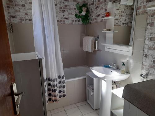 une salle de bain avec un lavabo et une baignoire dans l'établissement Maison T3 avec cour, à deux pas du port de l'Aiguillon, proche commodités et plage - Arcachon - FR-1-319-126, à Arcachon