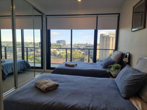 a bedroom with two beds and a large window at 2 Bedrooms Aptmt with Ocean View in Geelong