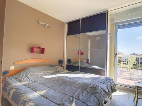 une chambre avec un lit et une grande fenêtre dans l'établissement Bel F2 Cabine avec Garage, Proche Plage et Port, Grande Terrasse ensoleillée - FR-1-715-80, à Mauguio