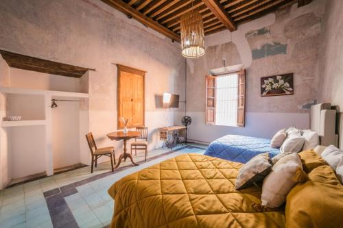 a bedroom with two beds and a table at Casa las Fuentes in Guanajuato