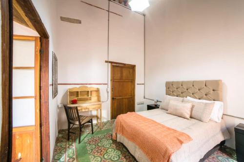 a bedroom with a bed and a table and a chair at Casa las Fuentes in Guanajuato