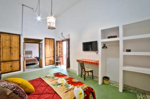 a bedroom with a bed and a desk in a room at Casa las Fuentes in Guanajuato