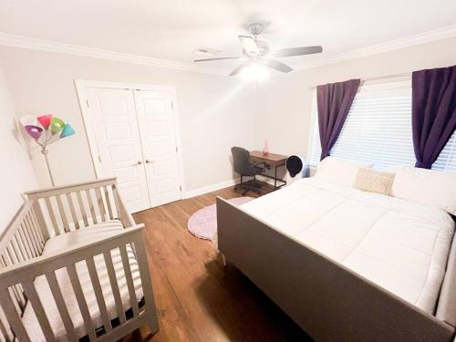 a bedroom with a bed and a ceiling fan at Mid City ranch! Huge backyard/Private pool! in Baton Rouge