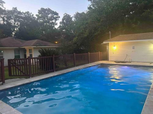 une grande piscine bleue en face d'une maison dans l'établissement Mid City ranch! Huge backyard/Private pool!, à Bâton-Rouge