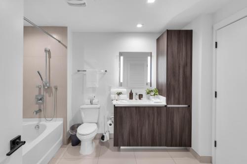 a bathroom with a toilet and a sink and a tub at Modern 1 Bedroom In The Heart Of Downtown Doral in Hialeah Gardens