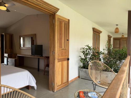 a bedroom with a bed and a desk with a television at Finca del Café - Casa Bourbon in Santa Rosa de Cabal