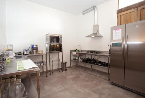 a kitchen with a stainless steel refrigerator and counters at Arche Noah Boutique Hostel in Bogotá
