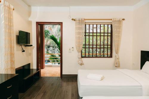 um quarto com uma cama branca e uma janela em Trang An Heritage Garden em Ninh Binh
