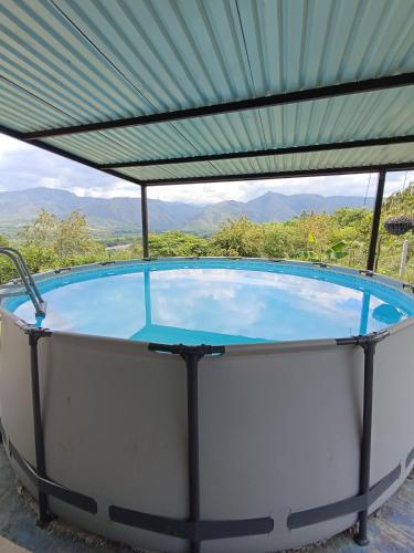 a large swimming pool with a green roof at Fresca casa de descanso en La Jagua in Garzón